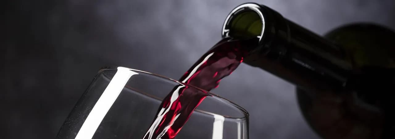 Rotwein wird ins Glas eingeschenkt