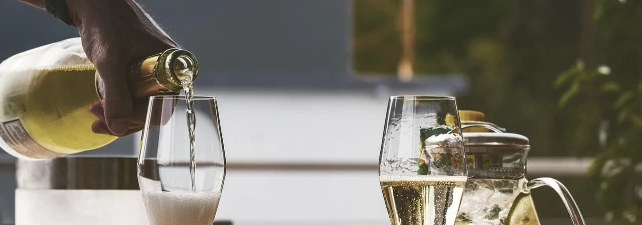 Schaumwein wird in Gläser eingeschenkt